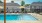 pool area with reclining seats and landscaping